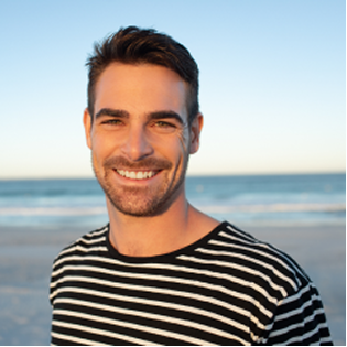 happy-man-standing-beach 1